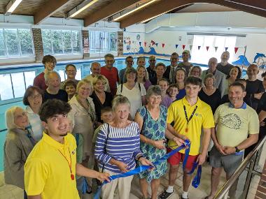 Ringmer residents and pool supporters Joyce Wiles (left) and Angela Glaysher (right) cut the ribbon with Wave Active lifeguards at the official re-opening of Ringmer Swimming Pool on Saturday